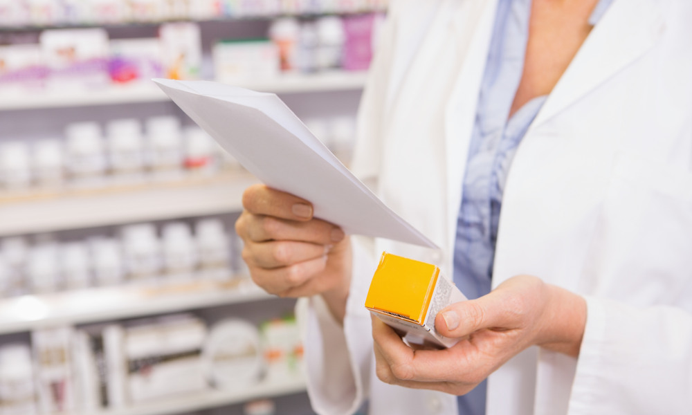 Pharmacist looking at prescription and medicine in the pharmacy