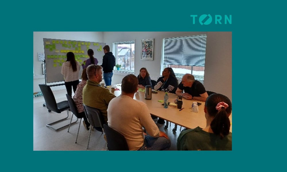 Arbeidsgruppe som jobber med posti-its og oppgavekartlegging
