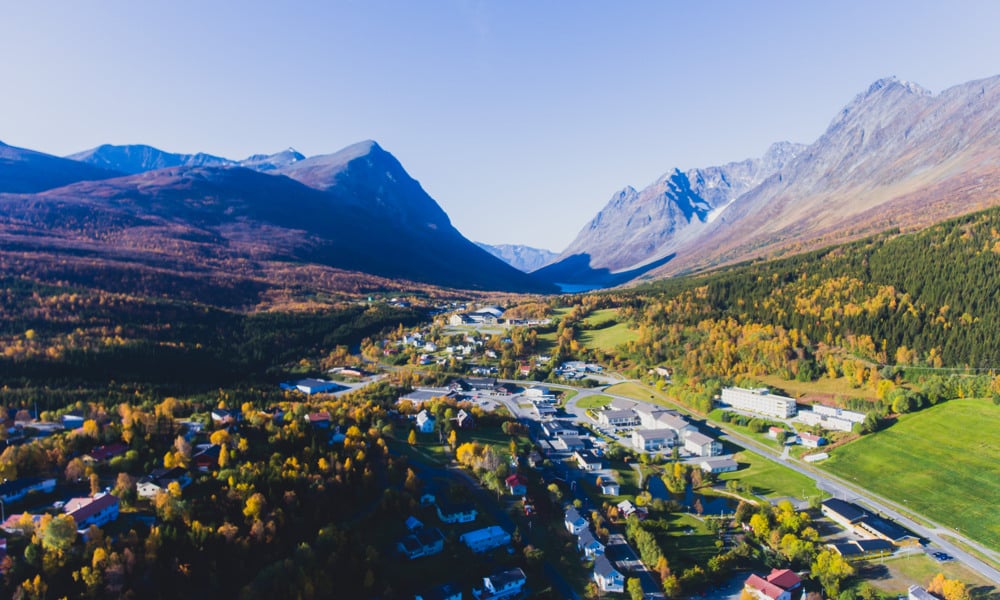 Classic norwegian scandinavian summer mountain landscape view with road, mountains and fjord with a blue sky, northern Norway, Finnmark County, shot from drone