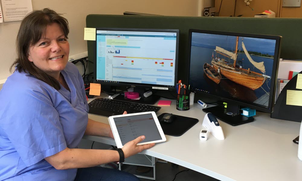 Linda Nilsen Augland, klinisk sykepleier, holder en iPad. 